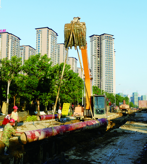 明德路段大型機(jī)械正進(jìn)行挖土和鋪埋污水管道。 (3).jpg